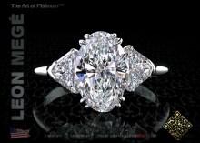 Three stone engagement ring featuring a 2.12 carat oval cut diamond with trillion side stones by Leon Megé.